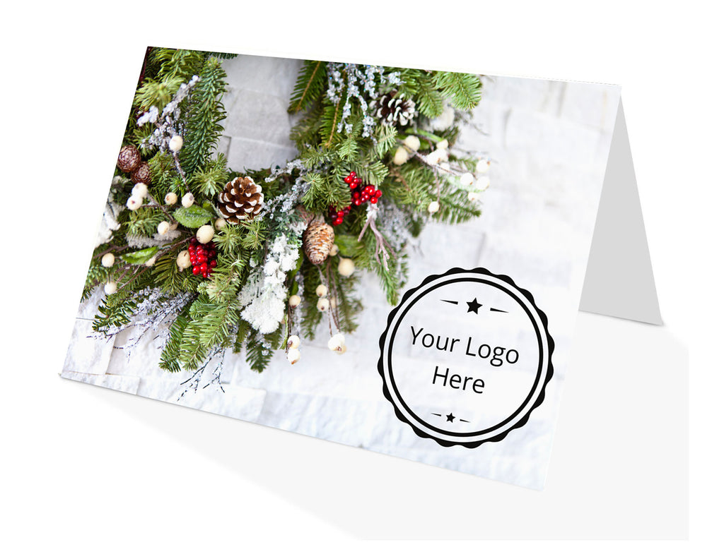 Holiday card with winter wreath on white brick